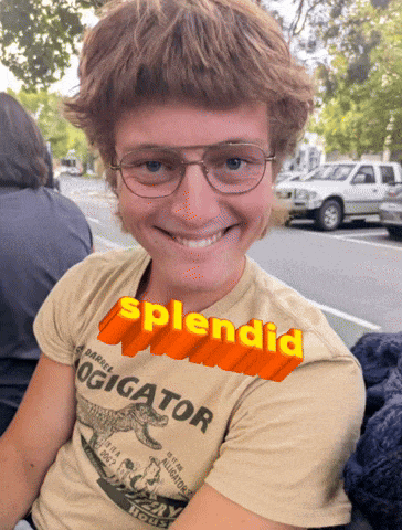 a young man wearing glasses and a t-shirt that says ' splendid ' on it