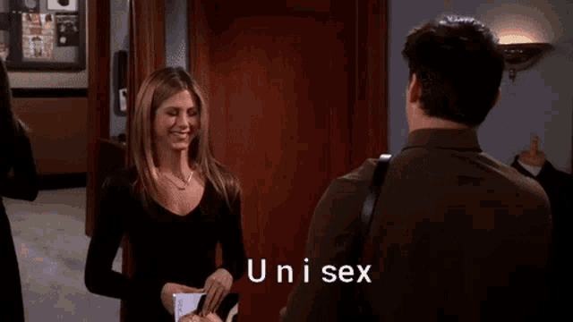 a woman in a black top is talking to a man in a green shirt who says " unisex "