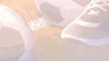 a close up of a soccer ball and a pair of shoes with the letter x on them