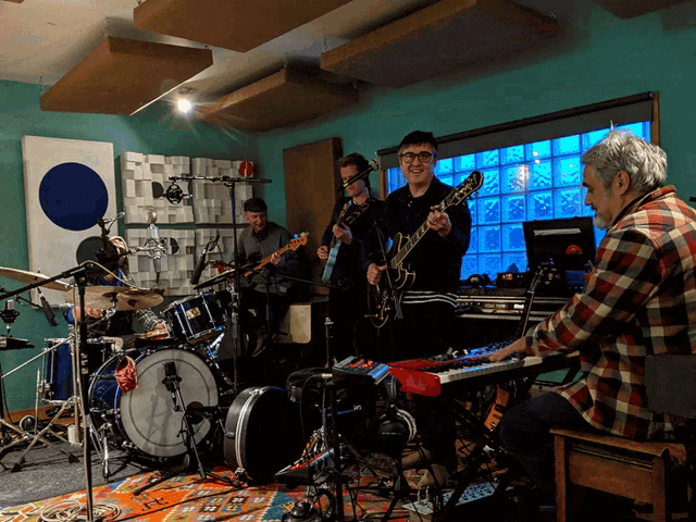 a man is playing a keyboard in front of a band