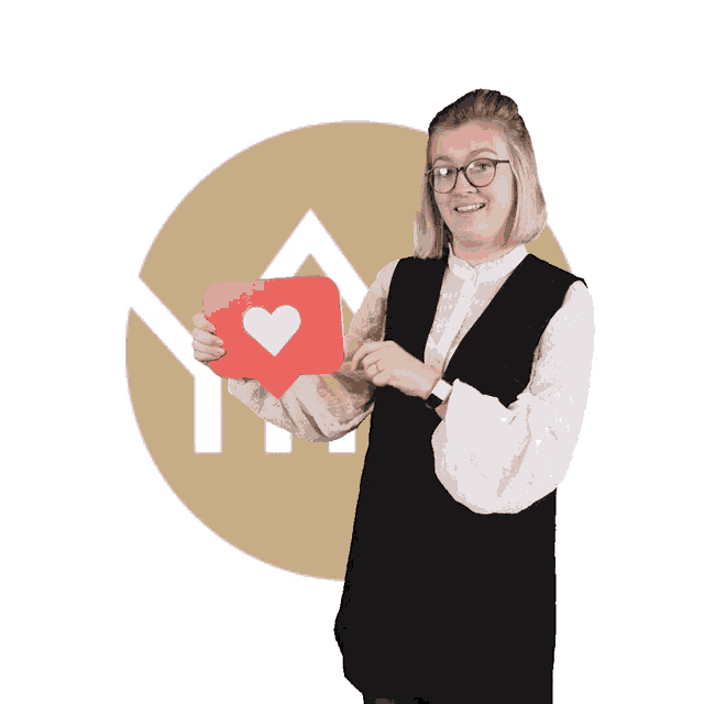a woman is holding a red heart shaped sign