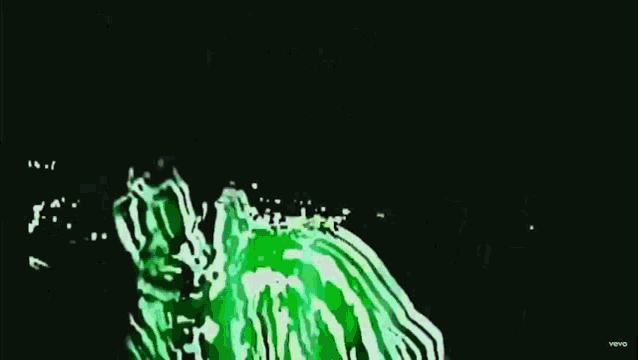 a man is driving a car at night with a green light coming out of his mouth .
