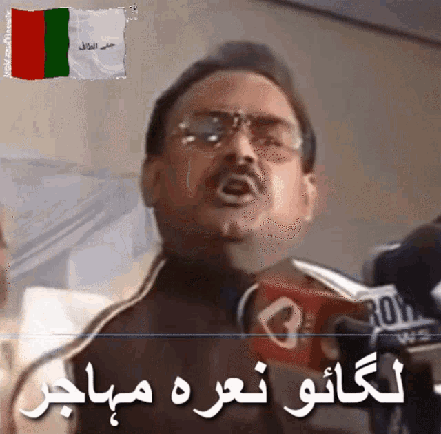 a man speaking into a microphone with a flag behind him that says ' afghanistan '