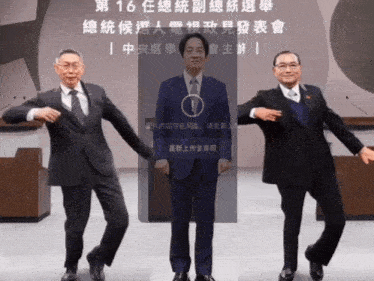 three men in suits are dancing in front of a sign that says ' 16 ' on it