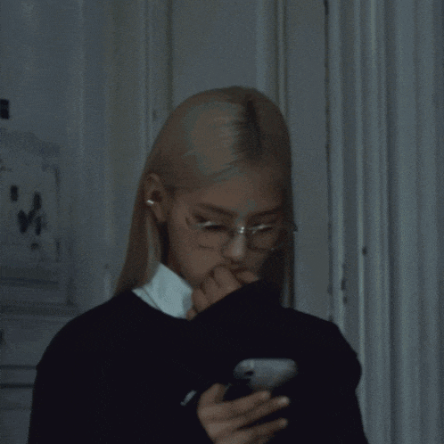 a woman with long blonde hair is standing in front of a door
