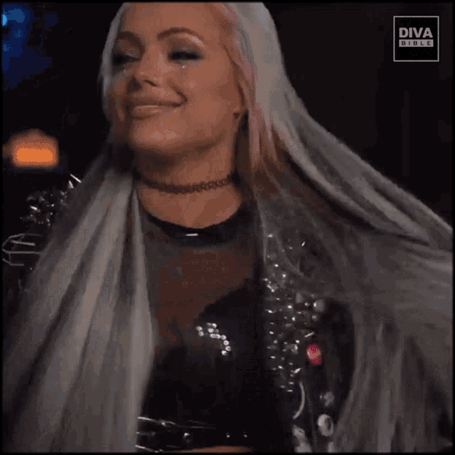 a woman is wearing a black leather jacket with the words liv 2 riott on the back