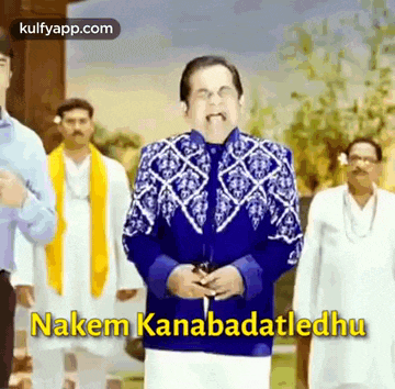 a man in a blue jacket is standing in front of a group of men and says nakem kanabadatledhu .