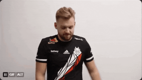 a man with a beard wearing a black shirt with red bull on it