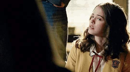 a girl wearing a yellow jacket with the letter s on the badge