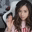 a blurry picture of a girl sitting in a chair with her hand up .