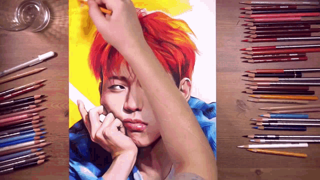 a drawing of a man with red hair is on a wooden table surrounded by colored pencils