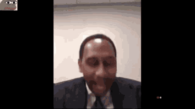 a man in a suit and tie is making a funny face with a frog behind him