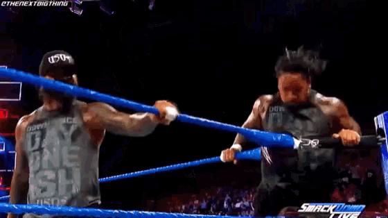 a couple of men are dancing on a stage with the words smackdown live on the bottom