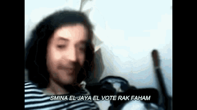 a blurry picture of a man with the words " smina el jaya el vote rak faham " written below him