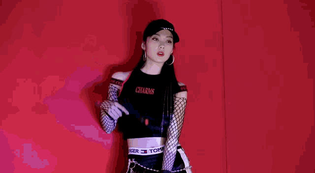 a young woman is holding a gun in her hand while wearing a hat and fishnet stockings .