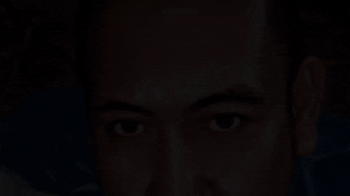 a close up of a man 's face with a dark background