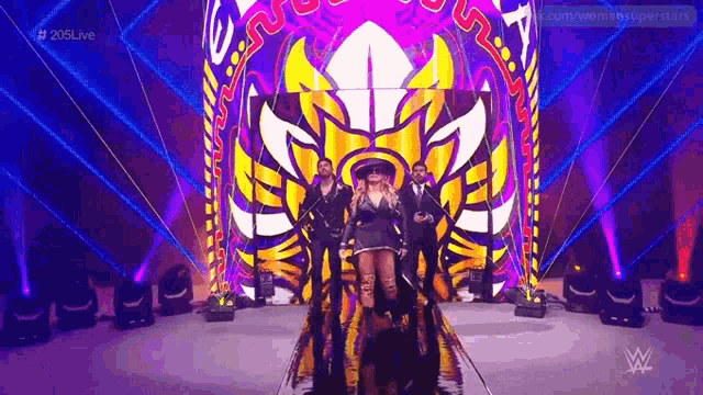 a woman in a sombrero is walking down a ramp in front of a colorful stage .