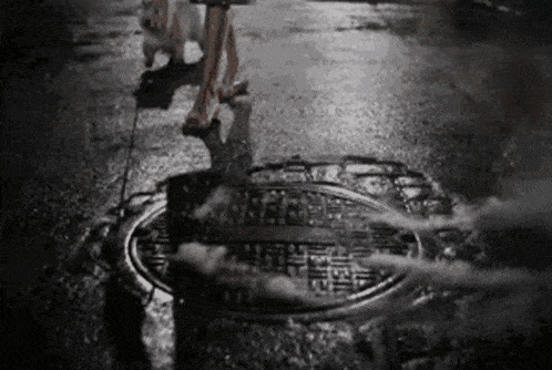 a black and white photo of a person walking a dog on a leash .