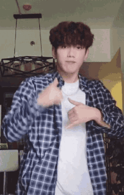 a young man in a plaid shirt and white shirt is dancing