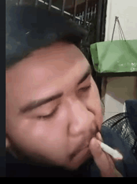 a close up of a man smoking a cigarette