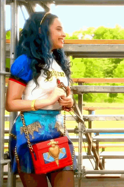 a woman with blue hair wearing a white shirt that says ' princess ' on it