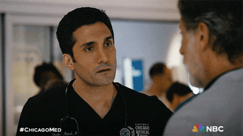 a man with a stethoscope around his neck is talking to another man in a chicago medical scene