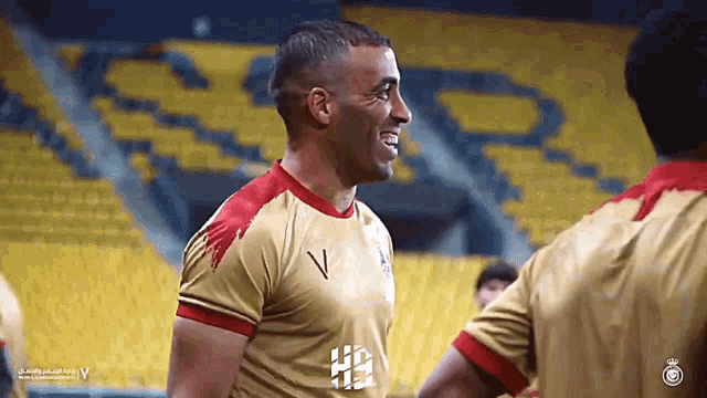 a soccer player wearing a gold jersey with the letter v on it