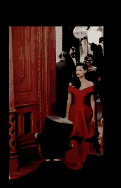 a woman in a red dress is standing in front of a sign that says ' apollo ' on it