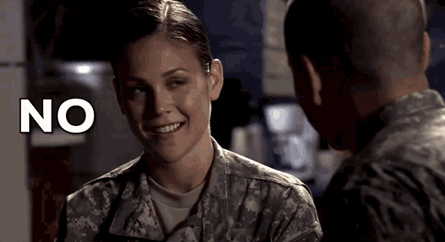 a woman in a military uniform smiles while looking at a man in a military uniform with the word no above her