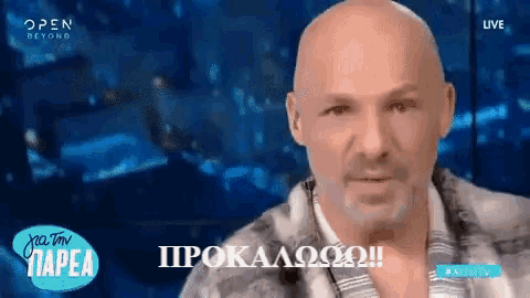 a bald man with a beard is on a tv screen with the words open beyond behind him