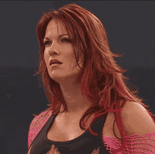 a woman with red hair is wearing a black tank top and pink straps