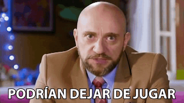 a bald man with a beard is wearing a suit and tie and has the words podrian dejar de jugar above him