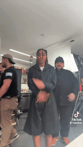 a group of people are dancing in a room with tik tok written on the bottom right