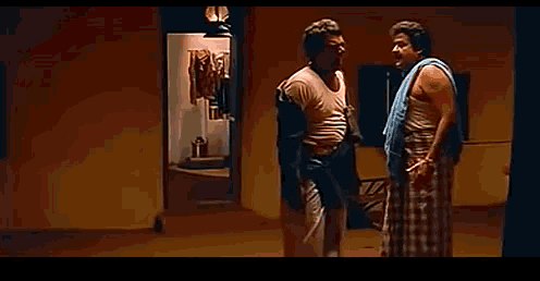 two men standing next to each other in a room