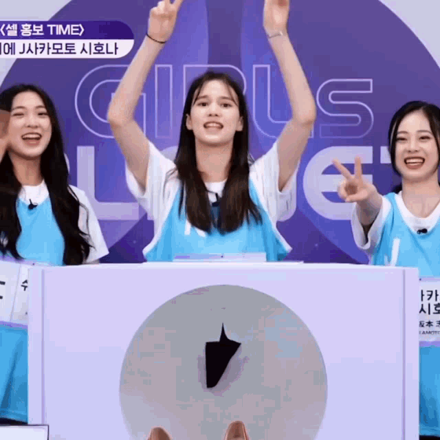 a girl with her arms in the air stands in front of a sign that says girls love