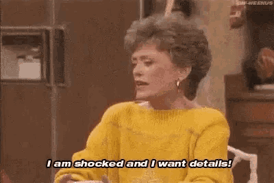 a woman in a yellow sweater is sitting at a table .