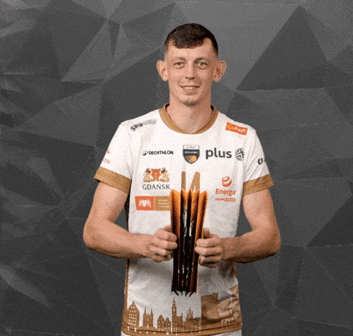 a man holding a trophy wearing a shirt with the word plus on it