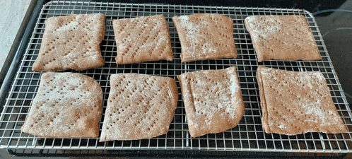 a bunch of crackers on a cooling rack with holes in them