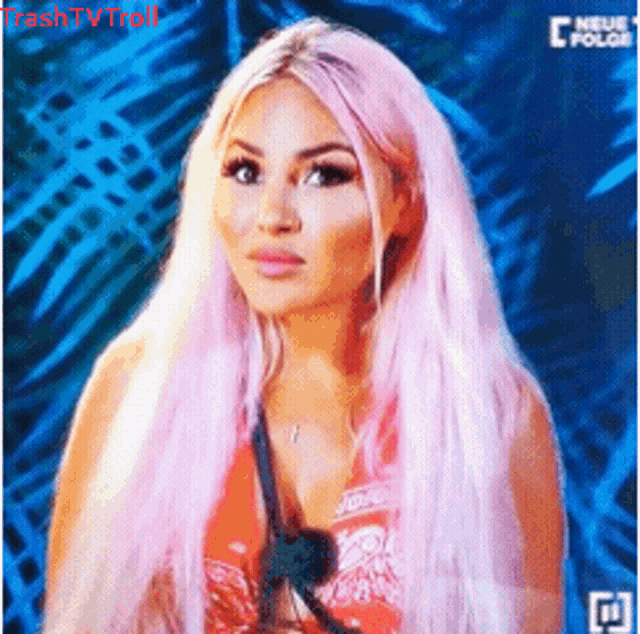 a woman with pink hair is wearing a red top and a necklace