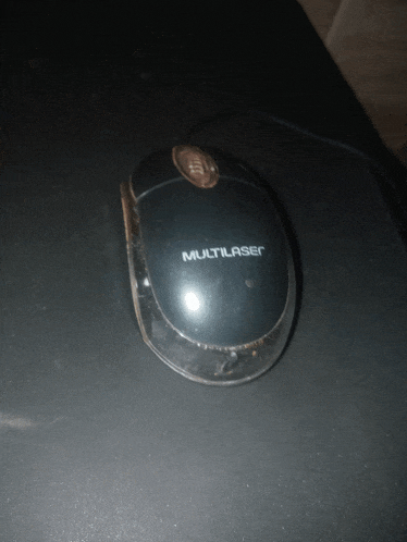 a black multilaser computer mouse sitting on a black surface