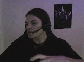 a man is making a heart shape with his hands while wearing headphones .