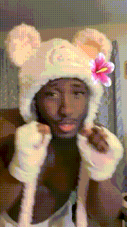 a man wearing a white hat with a pink flower on it