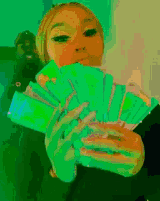 a woman is holding a bunch of money in her hands with the number 0 on it