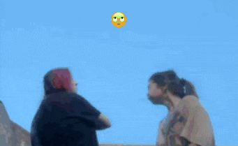 a yellow smiley face is floating in the blue sky