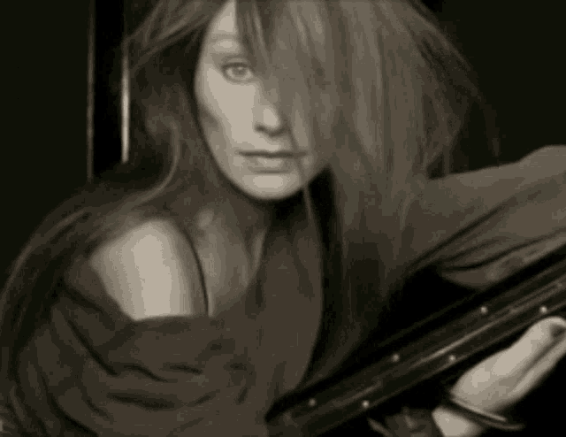 a woman with long hair is holding a purse