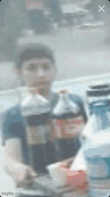 a blurry picture of a man sitting at a table with a bottle of coca cola
