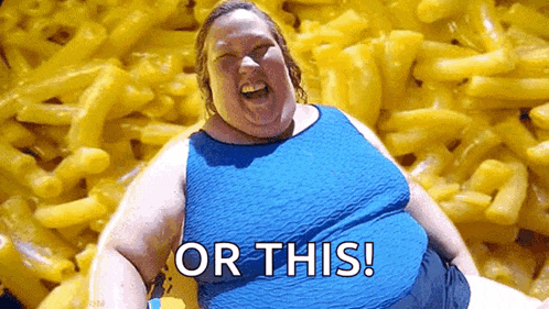 a fat woman is sitting in front of a pile of macaroni and cheese and laughing .