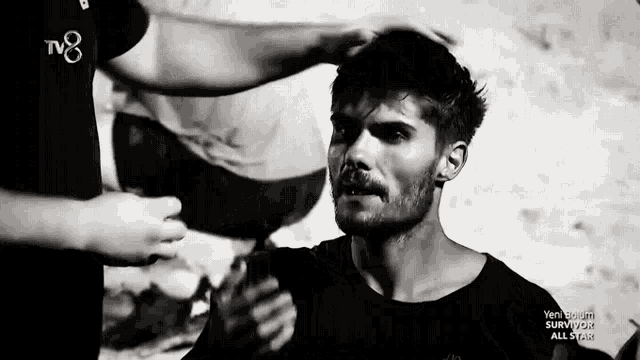 a black and white photo of a man with a tv8 logo on the bottom