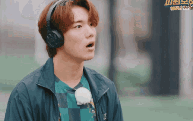 a man wearing headphones and a shirt with the letter ls on it