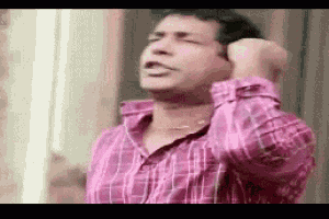 a man in a pink shirt is holding his head .
